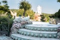 Old baroque stairs, outdoors. Stairs made of stone. Alley in beautiful garden with flowers and trees and frogs around. Royalty Free Stock Photo