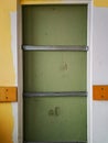 Old barred doors with footprints on inserted wall in old hospital