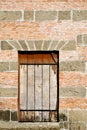 Old Barred Window on a Brick and Stone Wall Royalty Free Stock Photo