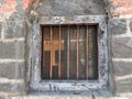 Old barred window on a weathered brick wall, conveying a sense of abandonment Royalty Free Stock Photo