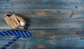 Old baseball glove, ball and neck tie on faded blue wood for happy fathers day concept Royalty Free Stock Photo