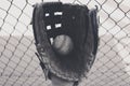 Old baseball in glove with dugout fence Royalty Free Stock Photo