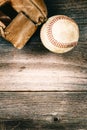 Old baseball and worn mitt on old wood with vintage style