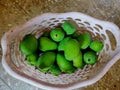 An old basked containing green raw mangoes