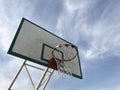 Old basketball hoop under view with blue sky background