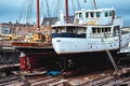 Old battered boats are being repaired at the dock. Royalty Free Stock Photo