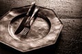 Old battered rustic pewter plate with cutlery