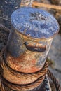 Old Battered Rusty Iron Bollard With Coiled Corroded Steel Cable