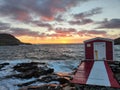 Old beach house on a pier placed on coastal rocks during a sunset Royalty Free Stock Photo