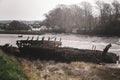 An old beached wooden boat falling apart and decaying at low tide Royalty Free Stock Photo