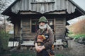 Old bearded forester posing in front of old wooden hut