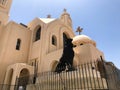 The old beautiful beige white stone orthodox Christian church is a place for praying to God with a cross and a statue of a black l