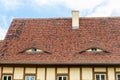 Old beautiful european german fachwerk building rooftop with eye shaped windows and chimney. Typical traditional ancoent Royalty Free Stock Photo