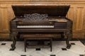 old beautiful gorgeous vintage grand piano standing against wooden background