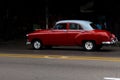 An old and beautiful red car driving through the streets of Havana Royalty Free Stock Photo