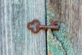 An old beautiful rusty key lies in a crack in the wooden wall Royalty Free Stock Photo