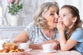 Close up portrait of old woman with a young girl drinking tea Royalty Free Stock Photo