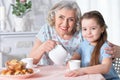 Old woman with a young girl drinking tea Royalty Free Stock Photo