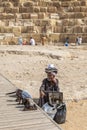 Old Bedouin man sell specific Egyptian souvenirs in front of the Giza Necropolis pyramids complex