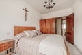 Old bedroom with varnished wooden furniture and a Catholic cross on the wall Royalty Free Stock Photo