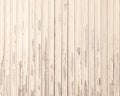 Old beige grungy paint blisters on vertical wooden planks