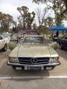 Old beige 1980 Mercedes Benz SLC C107 coupe in a park. AAA 2022 classic car show.