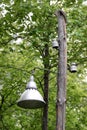 An old bell-shaped street lamp and two old-fashioned ceramic insulators mounted on an old wooden pole Royalty Free Stock Photo