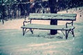 Old bench in the snow covered garden.