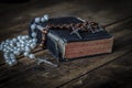 Old Bible with Catholic rosary on a table.