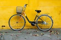 Old bicycle on a background of bright painted yellow wall.