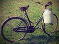 Old bicycle with a broken saddle and the milk can milkman