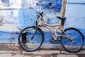 Bicycle leaning against an old blue painted wall Royalty Free Stock Photo