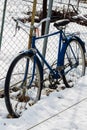 Old Bicycle leaning against the fence in winter Royalty Free Stock Photo