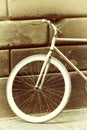 Old bicycle, painted white paint, the ancient stone wall