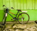 An old bicycle parked near green wall photo taken in Semarang Indonesia Royalty Free Stock Photo