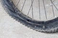 Old Bicycle wheel with flat tyre on road