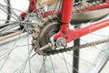 Old bicycle whell in red color with rusted chain