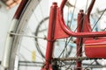 Old bicycle whell in red color with rusted chain