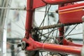 Old bicycle whell in red color with rusted chain