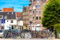 Old bicycles on the bridge in Amsterdam, Netherlands against a canal and old buildings during summer sunny day. Amsterdam postcard Royalty Free Stock Photo