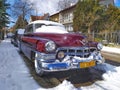 Veteran vintage oldtimer car Chevrolet covered with snow parked in Gdansk, March 12th, 2023.