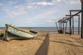 Old big fishing boat on the background of the sea, sand and broken Telfer overpass for launching boats in the old fishing village