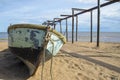 Old big fishing boat on the background of the sea, sand and broken Telfer overpass for launching boats in the old fishing