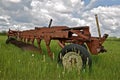 Old big plow parked in the grass