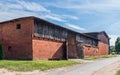 Old, big, wooden and brick barn with open wooden gate. Sunny, summer day in the countyside. KopaÃâ, Pomorze, Poland Royalty Free Stock Photo