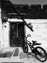 Old bike and white wall. Black and white photo. Indian countryside scene Royalty Free Stock Photo