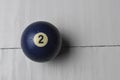 Old billiard ball number 2 blue color on white wooden table background, copy space Royalty Free Stock Photo