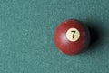 Old billiard ball number 7 brown color on green billiard table, copy space Royalty Free Stock Photo