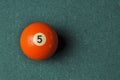 Old billiard ball number 5 orange color on green billiard table, copy space Royalty Free Stock Photo