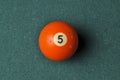 Old billiard ball number 5 orange color on green billiard table, copy space Royalty Free Stock Photo